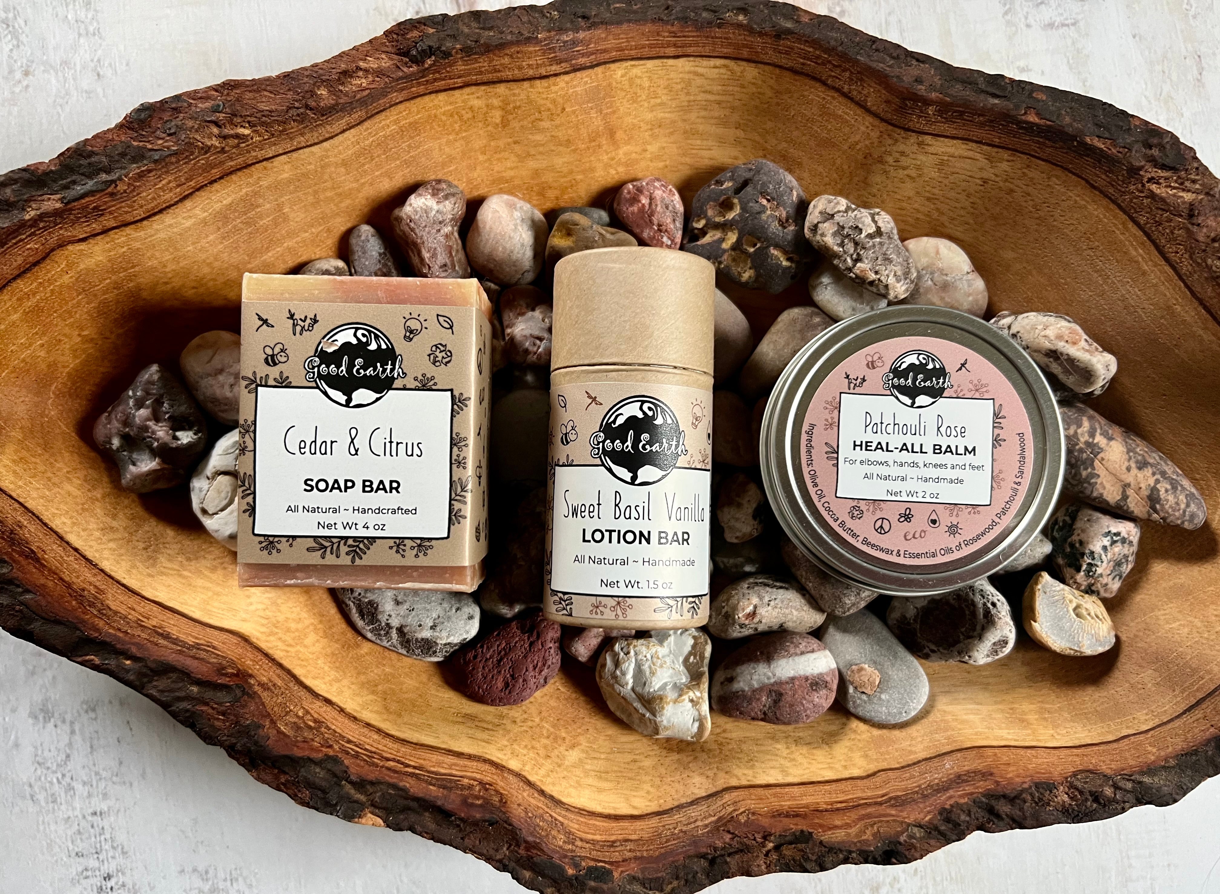 photo of natural handmade soap bar, lotion bar and healing balm on a piece of wood.